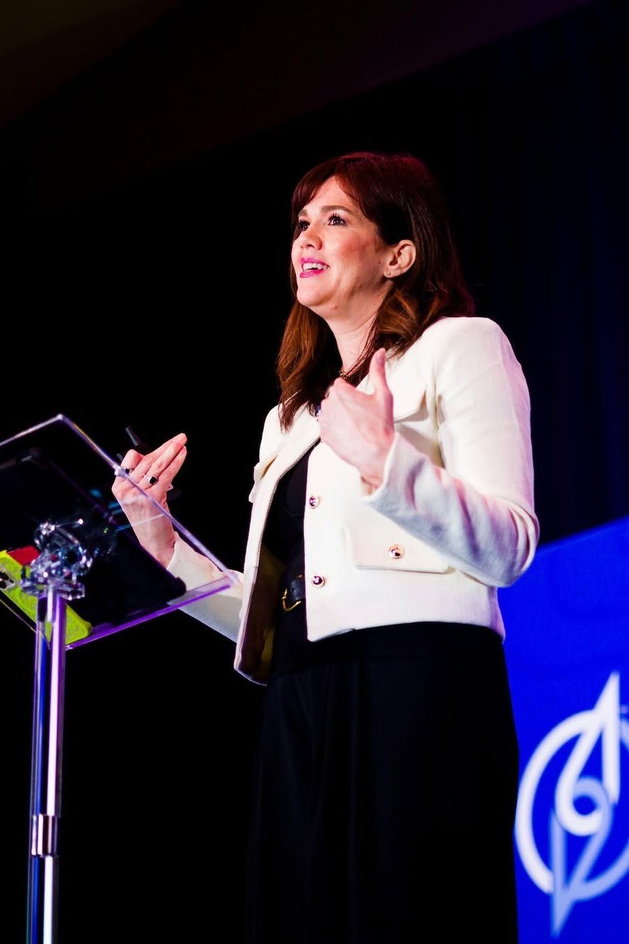 Kasey Brennan speaking on stage
